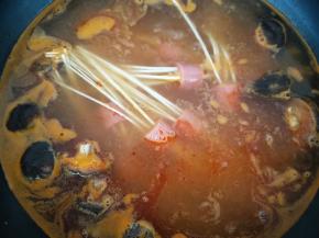 下入穿好的面条，一开始面条不能完全浸入汤汁中，不要硬压，期间用筷子轻轻搅拌，慢慢的面条变软，就会完全浸入汤汁中