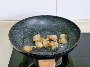 另起油锅，加入腌制好的贝肉翻炒2分钟，盛出备用。