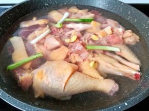 锅里放适量清水，放入土鸡生姜片，葱段。