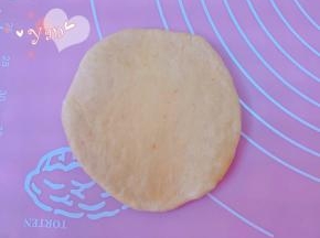 取松弛好的面团用手按扁，挤出大气泡。