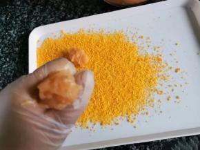 3、准备一会大一点的盘子，撒上面包糠。利用虎口位置和勺子分好大小。