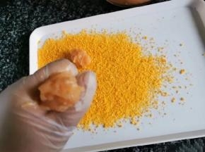 3、准备一会大一点的盘子，撒上面包糠。利用虎口位置和勺子分好大小。