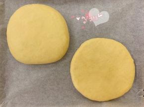 跟包包子一样包起来，收口捏紧。翻面，收口朝下。用擀面杖轻轻将面饼擀开到7寸大小，另一个面饼用同样的方法整形好，放到烤盘上。