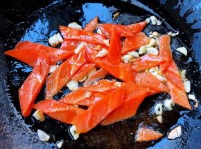 另起锅倒入底油加热放入蒜粒爆香再放入胡萝卜炒至断生