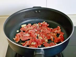 起油锅，加入切好的蒜末煸炒出香味，再加入腌制好的牛肉。
