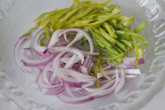 将切成丝的圆葱、尖椒放入一个干净，稍大一点的碗中。