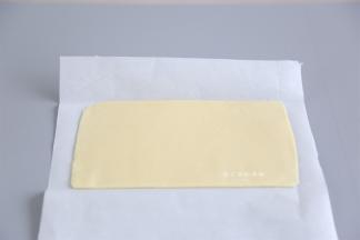 将油酥里面的材料混合成面团，记得黄油是室温软化的状态不是液化的状态，混合好的面团用油纸垫着，用擀面杖擀成长约30CM，宽15CM的方块，包好放入把冰箱里冷藏。