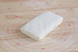 将1/3的面片折下再盖上另一个1/3的面片，就完成了第一次折叠，盖上保鲜膜松弛15-25分钟。