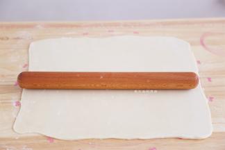 松弛好的面胚用擀面杖擀成长方形，长约45CM，宽约35CM，用力要均匀，不要擀破了哦。