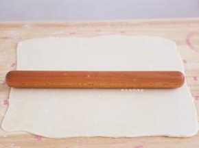 松弛好的面胚用擀面杖擀成长方形，长约45CM，宽约35CM，用力要均匀，不要擀破了哦。