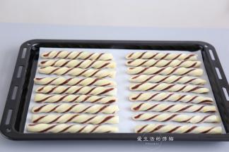 把蛋黄搅拌均匀，过筛一遍，涂在豆沙酥条上，喷上一层薄水。