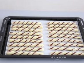 把蛋黄搅拌均匀，过筛一遍，涂在豆沙酥条上，喷上一层薄水。