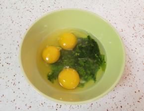 将菠菜碎末放入碗里，打入3个鸡蛋。