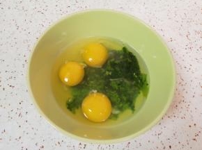 将菠菜碎末放入碗里，打入3个鸡蛋。