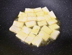 炒锅内倒适量的食用油烧热，下入豆腐块中火煎制。