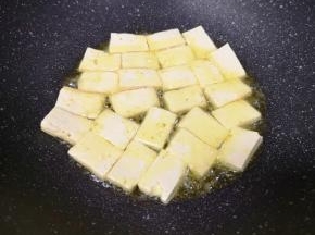 炒锅内倒适量的食用油烧热，下入豆腐块中火煎制。