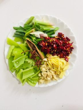 准备两个八角，一块桂皮，青椒切成块，蒜苗切成段，生姜切片，蒜瓣拍碎，干辣椒切成段备用！