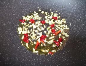 炒锅内倒适量的食用油烧热，下入蒜末和干红辣椒爆香。