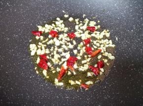 炒锅内倒适量的食用油烧热，下入蒜末和干红辣椒爆香。