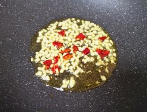 炒锅内倒适量的食用油烧热，下入蒜末和干红辣椒爆香。