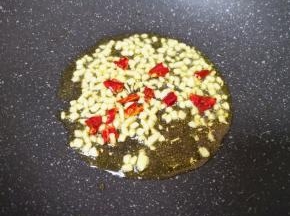 炒锅内倒适量的食用油烧热，下入蒜末和干红辣椒爆香。