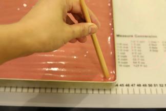 准备一根细的筷子，从烤盘的一角开始画。