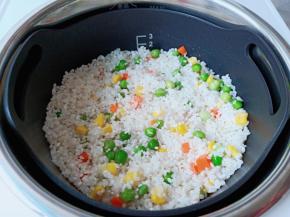 把大米倒入电饭煲里。