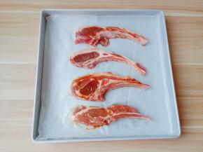 腌制好的羊小排放入烤盘【烤盘铺上一张油纸，清洗方便。】