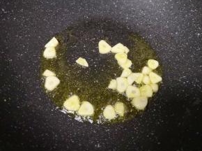 炒锅内继续倒入食用油烧热，下入蒜片爆香。