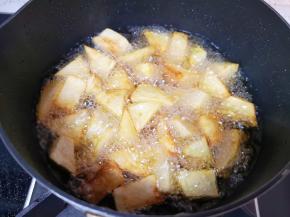 土豆块用厨房用纸吸一下表面的水分，炸锅内倒入多一些食用油烧热，下入土豆块炸至金黄色捞出备用。