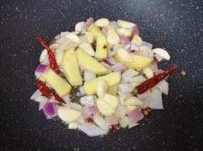 炒锅内倒适量的食用油烧热，下入大蒜、生姜、洋葱碎、花椒和干红辣椒炒香。
