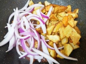 等到鸡块里面的汤汁剩一半的时候，下入洋葱和炸好的土豆胡萝卜。