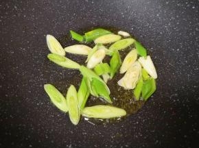 炒锅内倒适量的食用油烧热，下入蒜苗炒香。