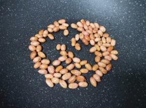 炒锅内倒少许食用油烧热，下入花生米小火炒熟，盛出晾凉备用。