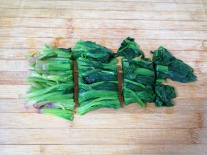 过过凉水的菠菜挤干水分，切成几段。