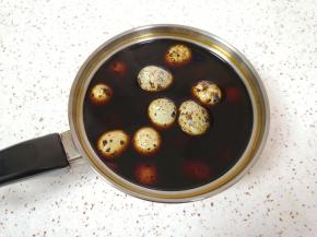 小锅里加入黄冰糖、盐和混合好的生抽老抽搅拌均匀，放入煮好的鹌鹑蛋。