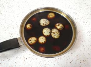 小锅里加入黄冰糖、盐和混合好的生抽老抽搅拌均匀，放入煮好的鹌鹑蛋。