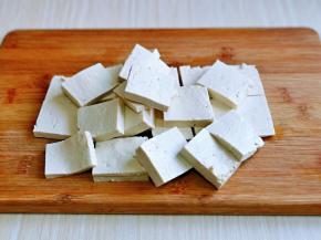 首先将老豆腐冷水冲洗一下，再切片，形状及厚度可以根据个人喜好来。