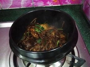 9.再撒点芝麻和香菜，最后将它们盛入已烧热的石锅中，听到滋滋声响后即刻离火，麻辣鲜香有嚼劲，好吃下饭又过瘾