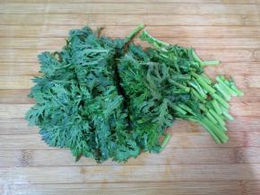 浸泡过的茼蒿清洗干净，控一下水分，切成小段。