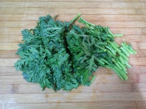 浸泡过的茼蒿清洗干净，控一下水分，切成小段。