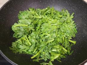 炒锅内倒适量的食用油烧热，下入茼蒿。