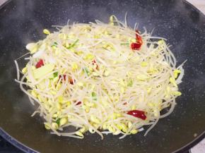 下入黄豆芽翻炒至豆芽变软。
