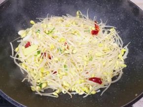 下入黄豆芽翻炒至豆芽变软。