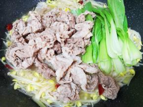 下入青菜和焯过的牛肉卷煮至入味。