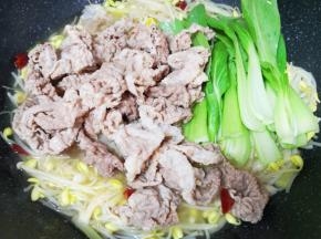 下入青菜和焯过的牛肉卷煮至入味。