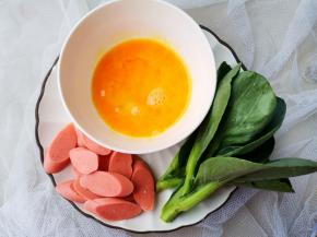 火腿切斜片，鸡蛋打散煎熟备用，青菜过下开水备用。