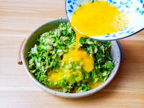 搅拌好的鸡蛋液倒入槐花碗里。