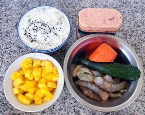 准备原材料米饭、菠萝去皮切丁、海虾去皮、午餐肉、黄瓜、胡萝卜