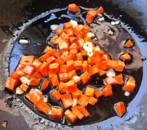 锅中倒入底油加热放入蒜粒爆香再放入胡萝卜炒至断生